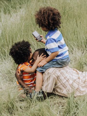 Family of two children and one parent in the grass