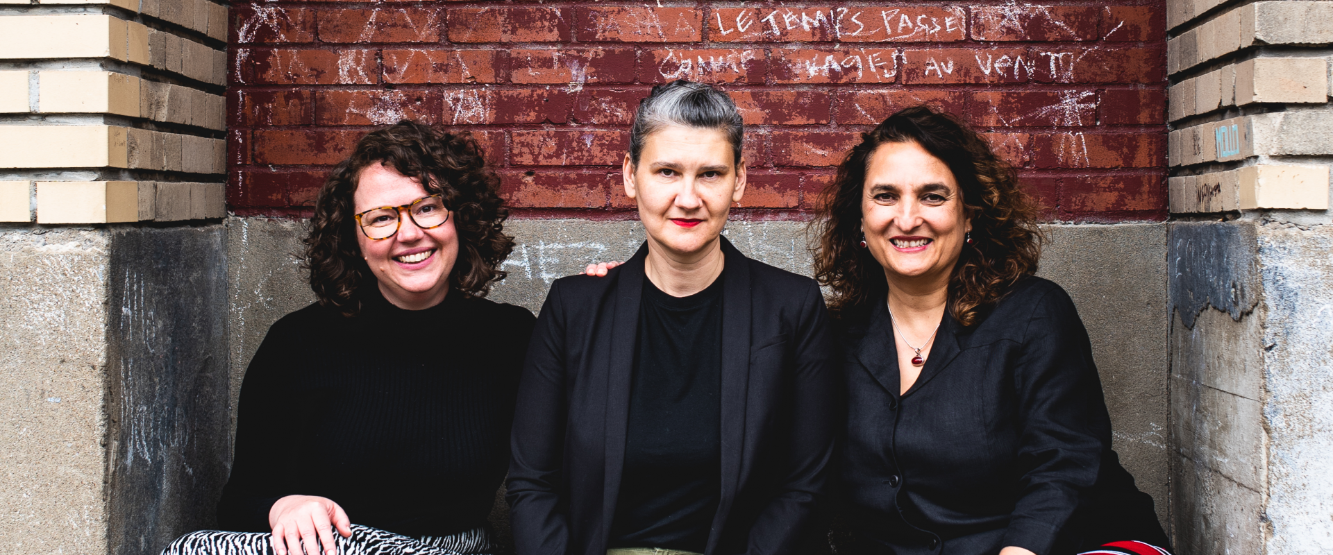 Photo de trois femmes assises sur un banc à l'extérieur